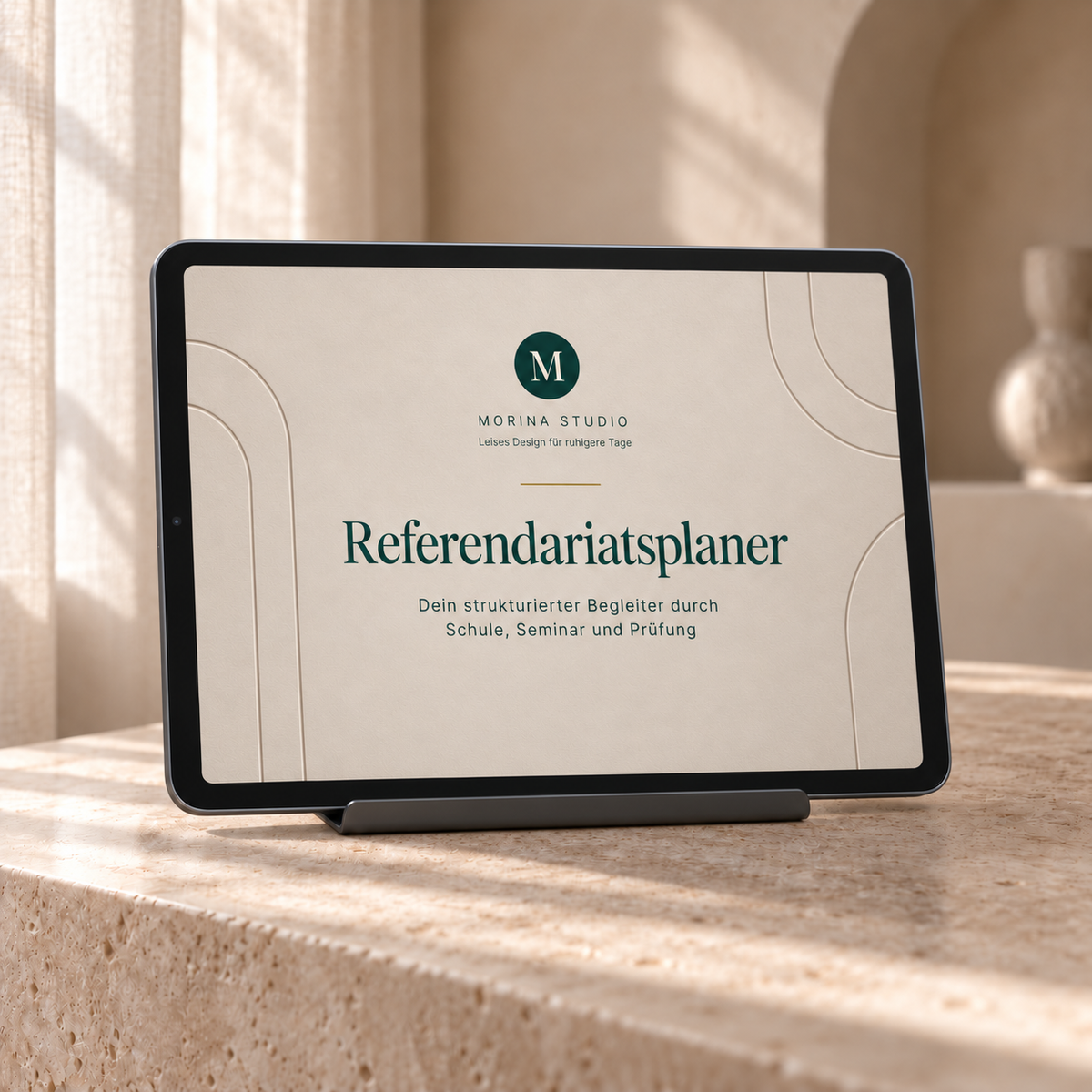 Tablet auf einer hellen Steinablage zeigt das beige Cover des digitalen Referendariatsplaners von Morina Studio.